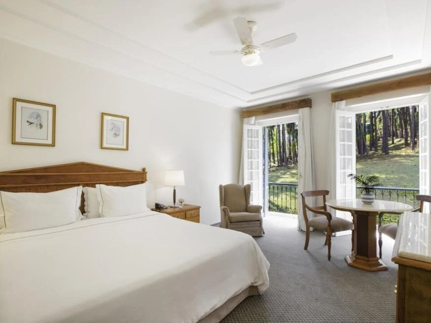 Cama e portas de acesso à varanda, categoria Luxo Superior do Hotel Fazenda Dona Carolina