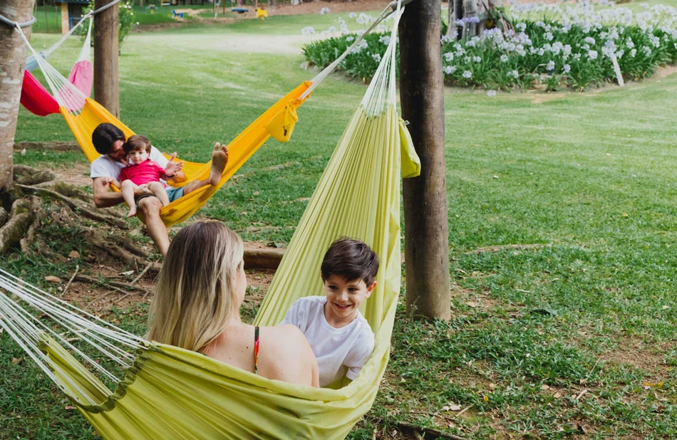 Famílias aproveitando as redes no jardim do hotel