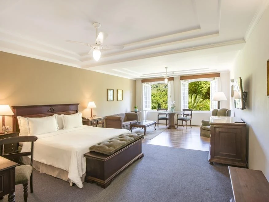 Vista ampla da cama e da sala de estar, categoria Suíte Master do Hotel Fazenda Dona Carolina